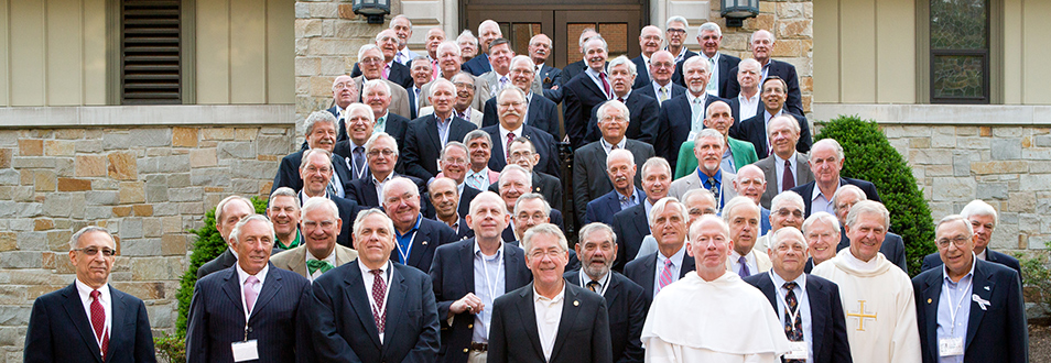 Class of 1966 alumni standing with Father Shanley